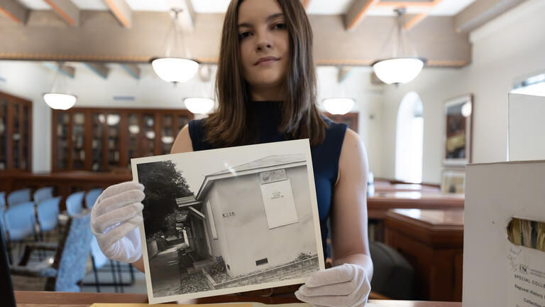 Amber Santoro with a photograph from the USC Libraries' Century Freeway Collection (Nick Neumann/USC Wrigley Institute)